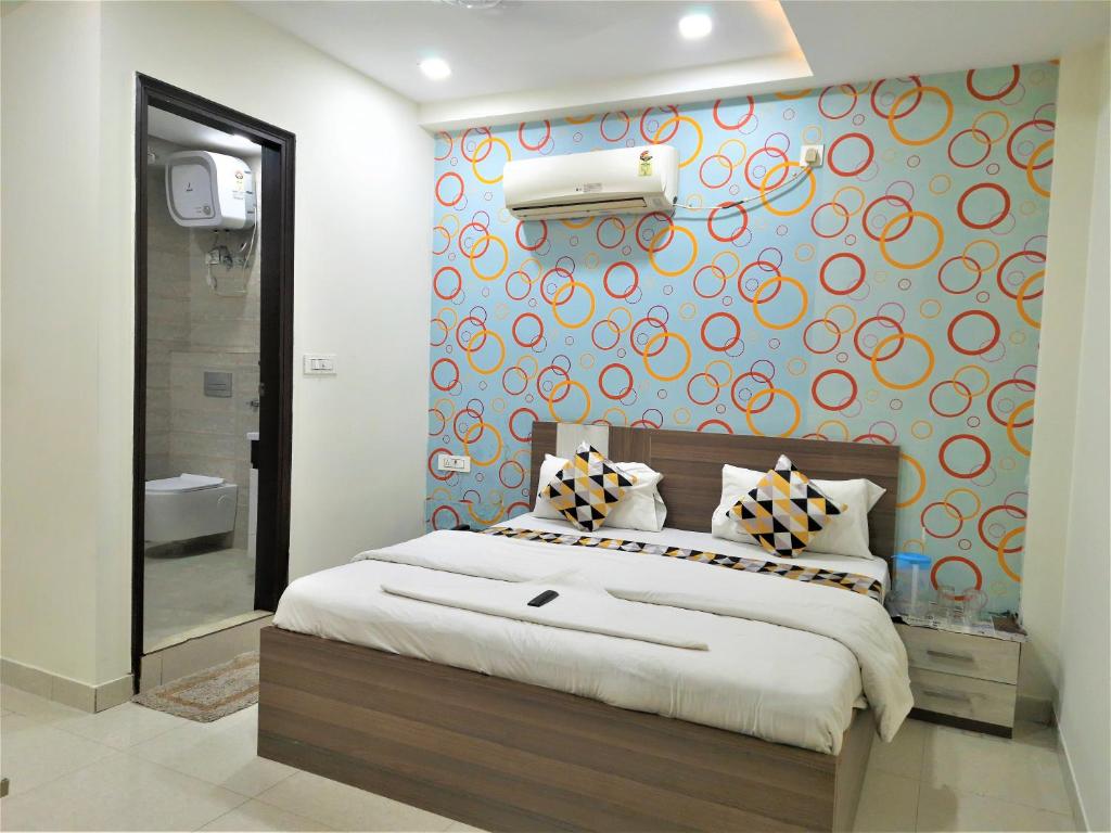 a bedroom with a large bed with a colorful wall at Hotel Le Heritage , Nizamudin Railway Station in New Delhi