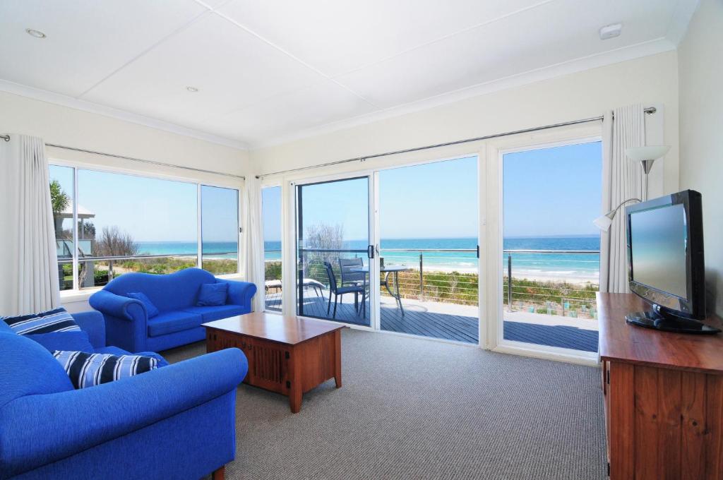 a living room with a blue couch and a television at Jervis Bay Waterfront in Vincentia