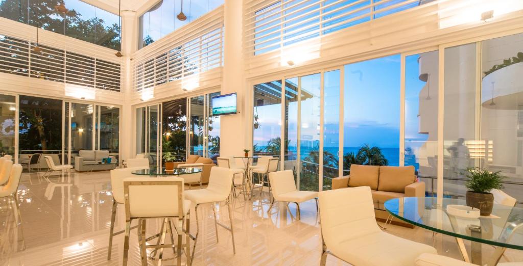 a large room with white chairs and tables and windows at Flamingo Hotel by the Beach, Penang in George Town