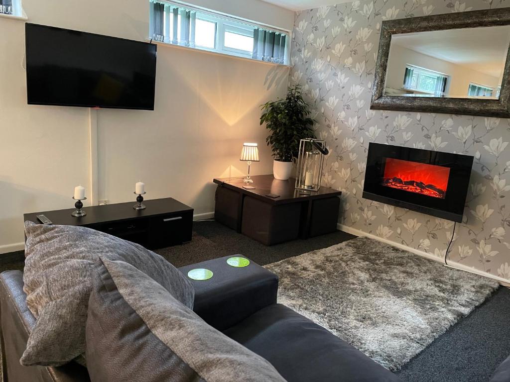 a living room with a couch and a fireplace at Hoffman Hideaway in Buxton