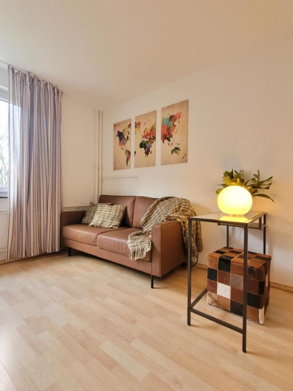 ein Wohnzimmer mit einem Sofa und einem Tisch in der Unterkunft Kupferberg - helles und gemütliches Appartement in Uninähe in Mainz