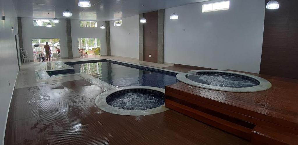 a swimming pool with two jacuzzis in a building at Flat-Hotel Cavalinho Branco (G08) in Águas de Lindóia