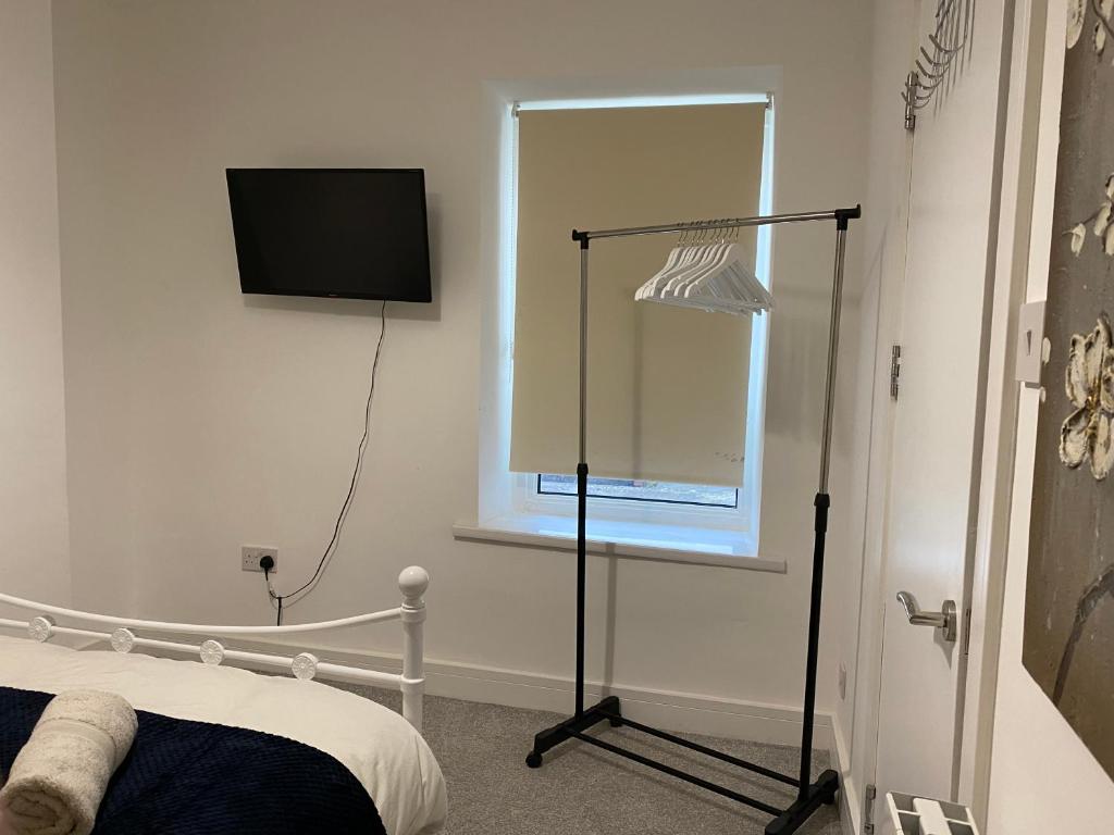 ein Schlafzimmer mit einem Bett und einem TV an der Wand in der Unterkunft Cosy 2 Bed Flat 1 in Bridgend in Bridgend