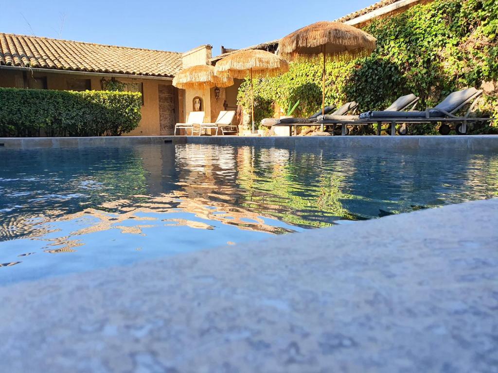 a swimming pool with umbrellas and chairs in a house at Le Mas de Mougins in Mougins