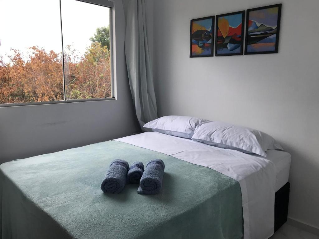 a bedroom with a bed with blue towels on it at Residencial Campeche 1 in Florianópolis