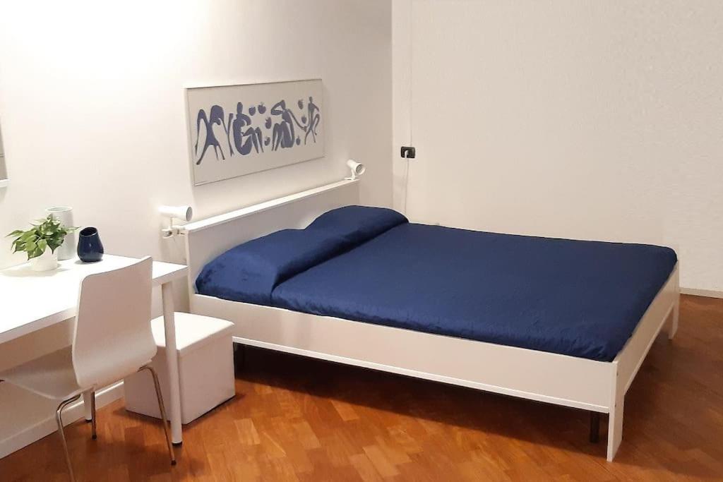 a bedroom with a bed and a table and a desk at B&B accogliente a due passi dal metrò di Milano - Casa Adriana in Cologno Monzese