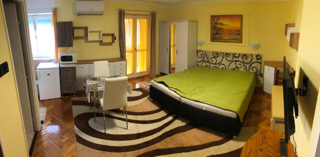 - une chambre avec un lit et une table dans l'établissement BB apartman, à Harkány
