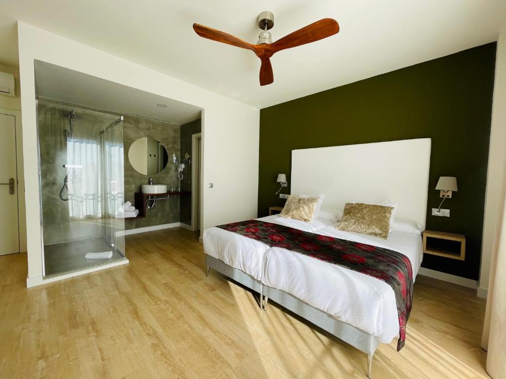 a bedroom with a bed and a ceiling fan at Añoreta Suites in Rincón de la Victoria