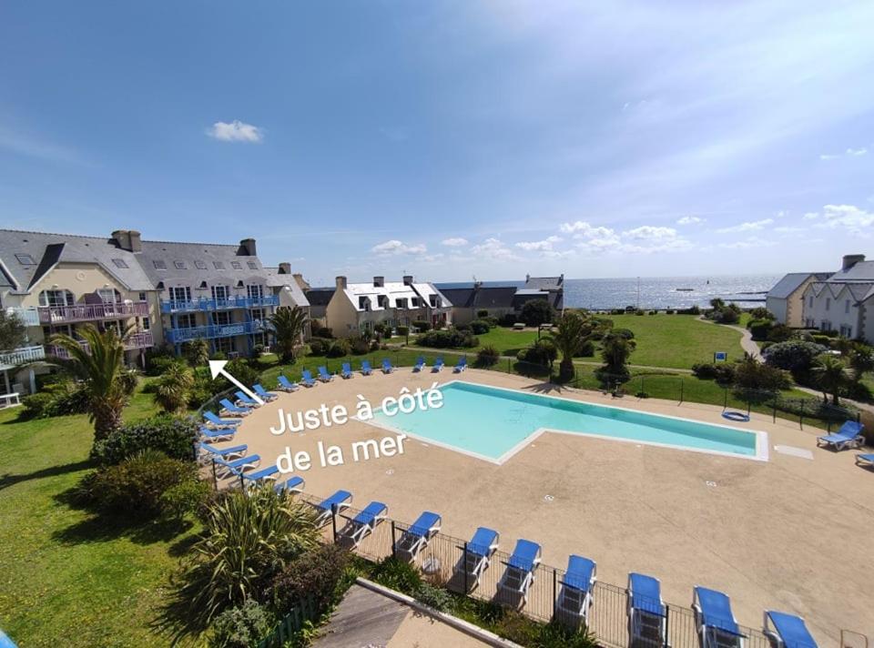 uma vista aérea de um resort com uma piscina e cadeiras em LocaLise au Guilvinec - B5 - Plain-pied avec piscine et jardin - Tout à pied, plage, port, centre, commerces, marché - Wifi inclus - Linge de lit inclus - Animaux bienvenus em Le Guilvinec