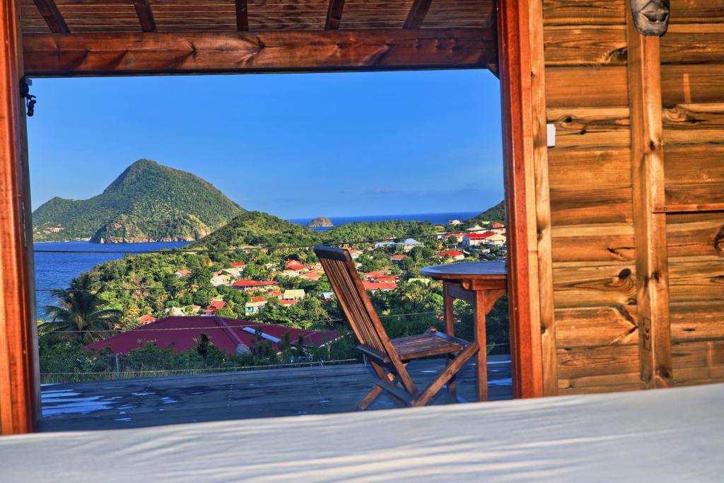 a room with a window looking out at the ocean at TI KAZ ANOLI Cottage en bois avec vue sur la baie in Terre-de-Bas