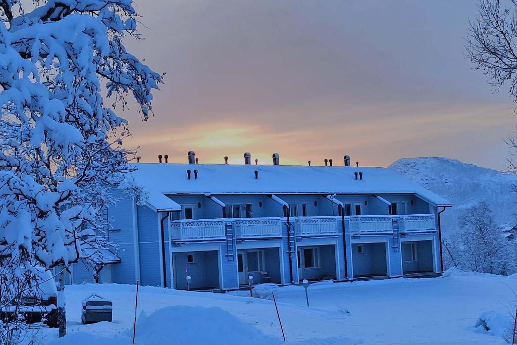budynek ze śniegiem na dachu w obiekcie Panorama Blue Apartments w mieście Kilpisjärvi