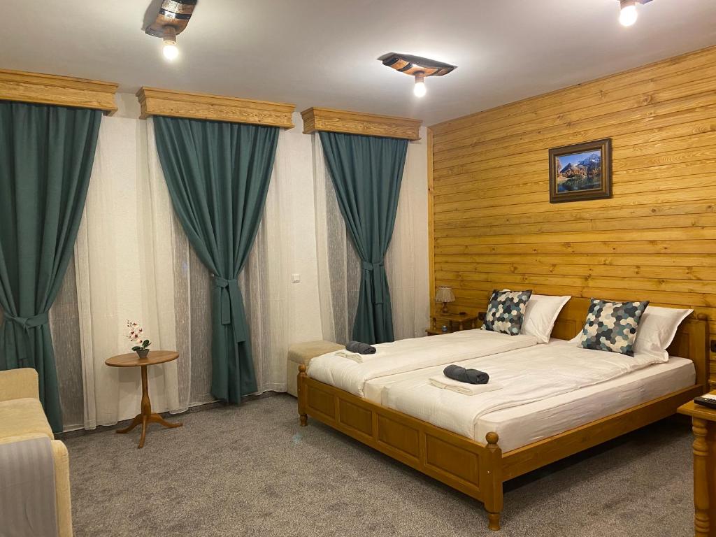 a bedroom with a large bed with green curtains at Luxury private studio in Green Life Bansko in Bansko