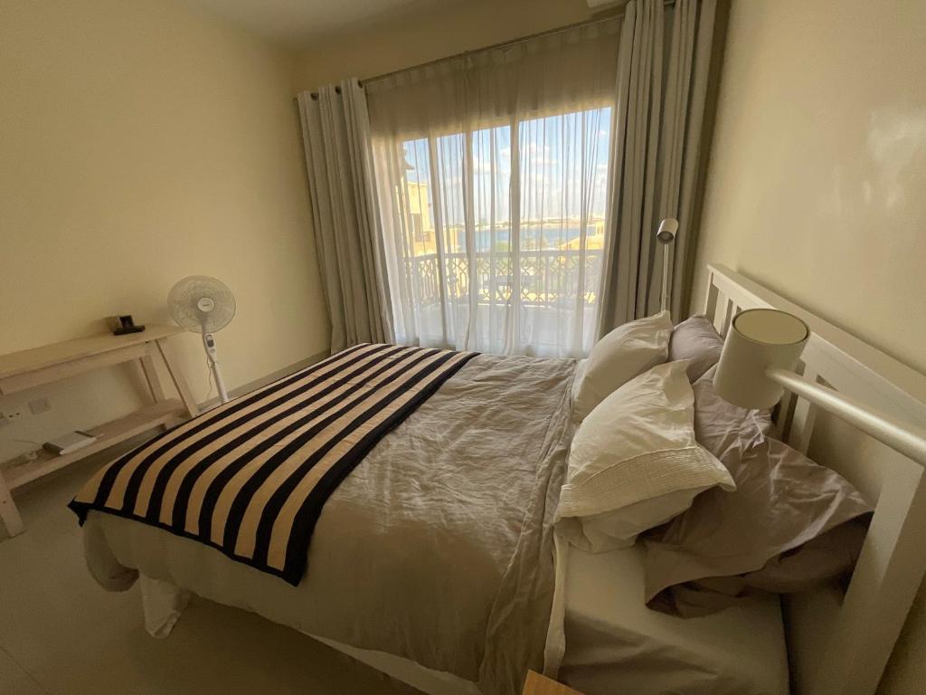 a bedroom with a bed with a window at 1 Bedroom Hideaway On The Beach in Ras al Khaimah