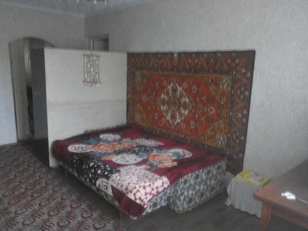 Окрема кімната без підселення в трикімнатній квартирі біля метро Оболонь في كييف: غرفة نوم بسرير لحاف احمر وبيض