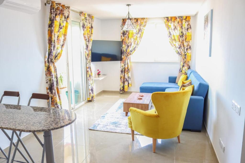 sala de estar con sofá azul y sillas amarillas en Coin Du Ciel-Vue Imprenable Océan avec piscine en Agadir