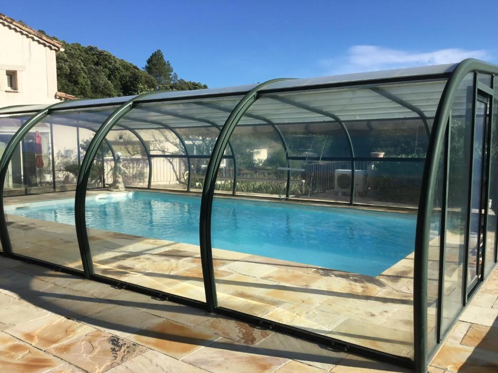 a glass bridge over a swimming pool in a building at Mas Auziere in Le Martinet