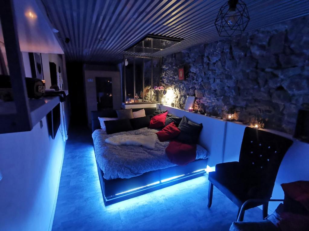 - une chambre avec un lit et un mur en pierre dans l'établissement Sweet Loft Grenoble-Love Room avec jacuzzi & sauna, à Grenoble