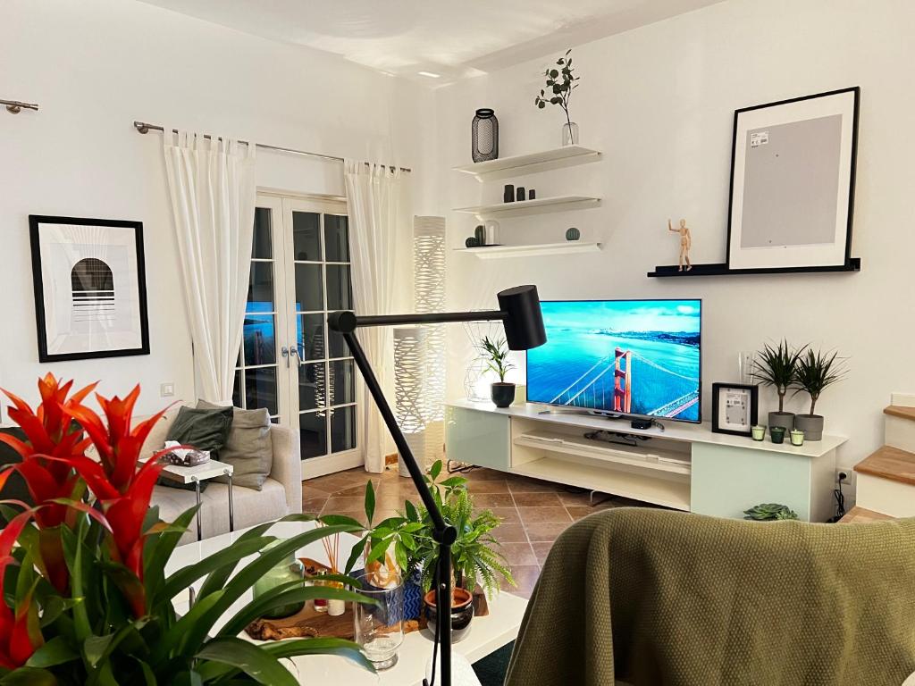 a living room with a large screen tv in it at Sea Canal Townhouse in Göcek