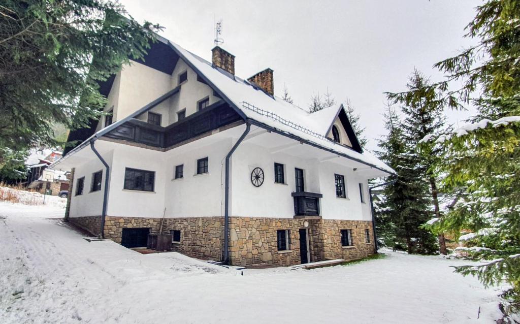 a large white building with a clock on it in the snow at Willa Jaszczurówka in Zakopane