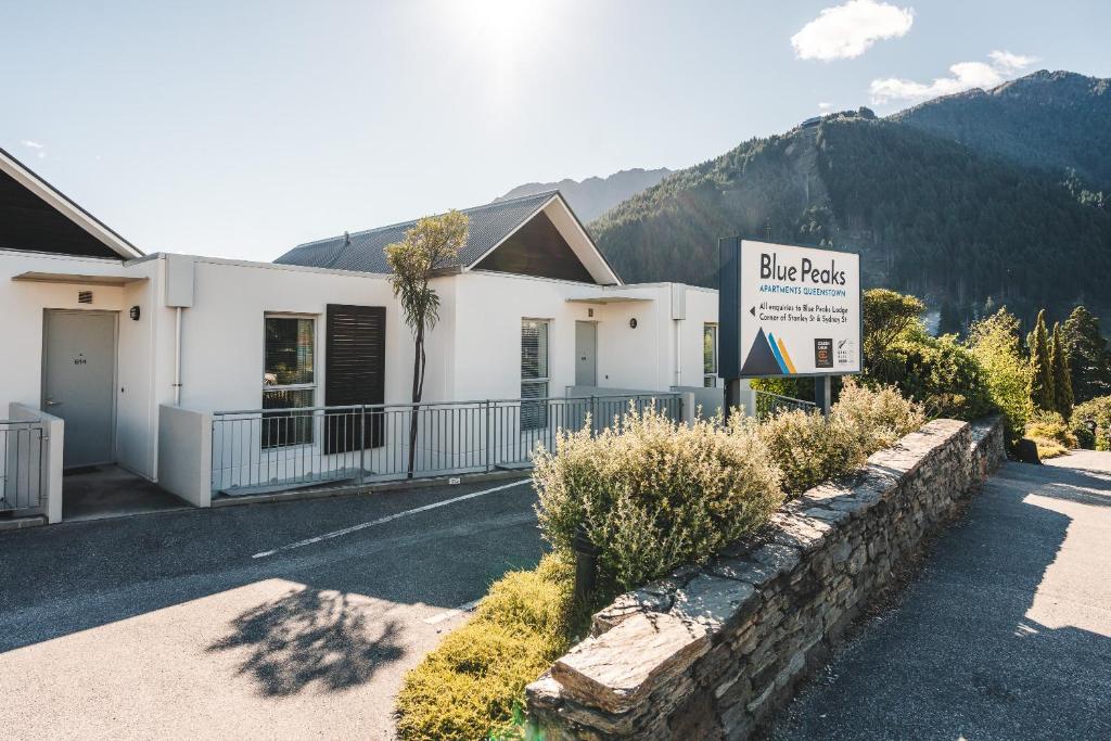 a white building with a sign in front of it at Blue Peaks Apartments in Queenstown