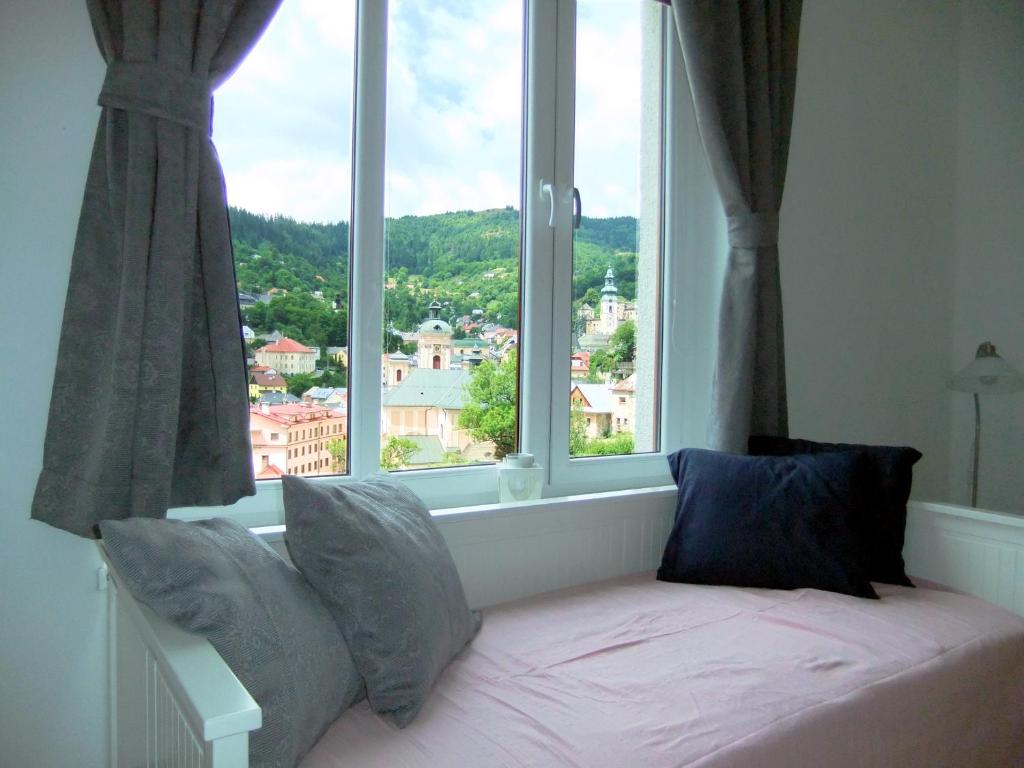 una cama en una habitación con una ventana grande en PANORAMA apartmán ajaj, en Banská Štiavnica