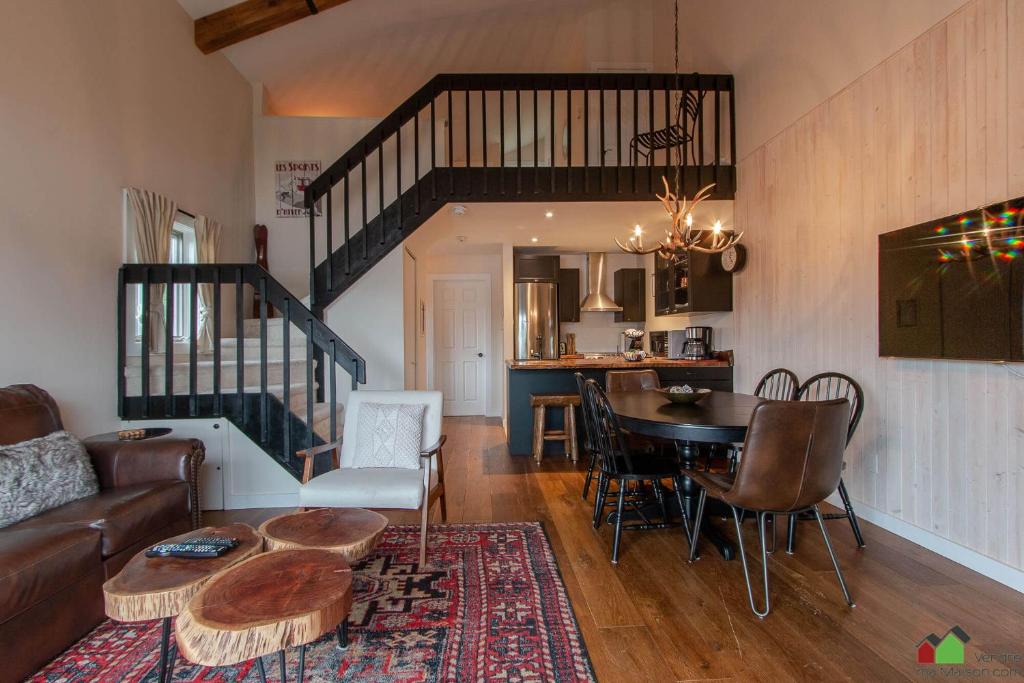 een woonkamer met een bank en een tafel bij Unique Tremblant view -fancy fully equipped apartment in Mont-Tremblant