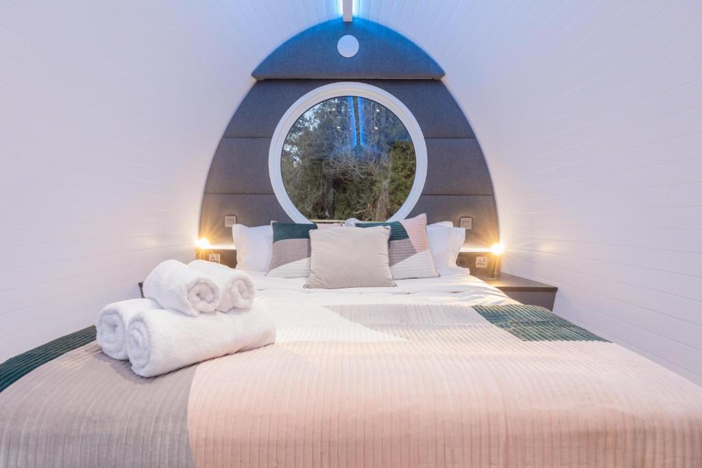 a bedroom with a large bed with a round window at The Secret Hideaway in Penicuik