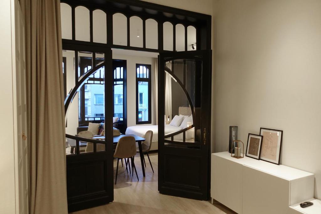 een kamer met een slaapkamer met een bed en een spiegel bij Casa Clementina - 3 Bedroom Apartment in a Art-Nouveau House in Gent