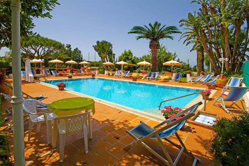 a large swimming pool with chairs and umbrellas at Hotel Park Calitto in Ischia