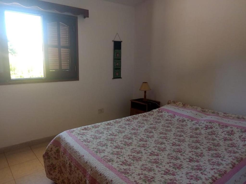 Schlafzimmer mit einem Bett und einem Fenster in der Unterkunft Rada in Embalse