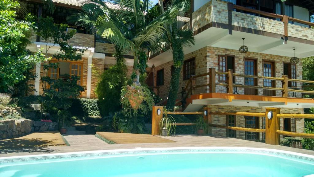 une maison avec une piscine en face de celle-ci dans l'établissement Pousada Vista da Barra, à Florianópolis