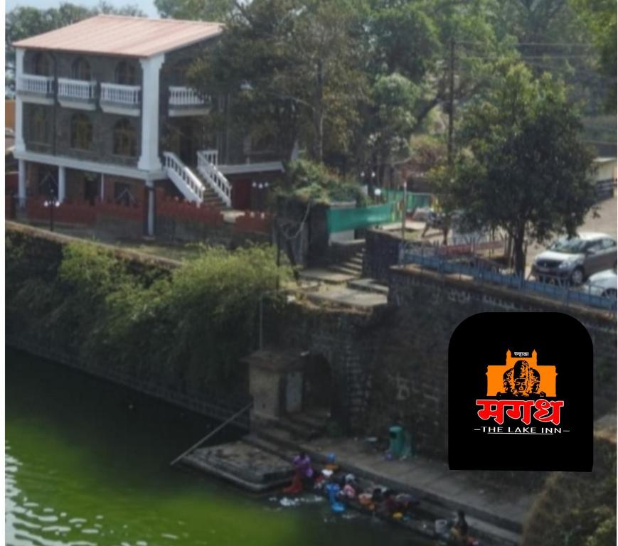 a view of a building next to a body of water at Magadh ,In Fort Panhala Hotel in Panhāla