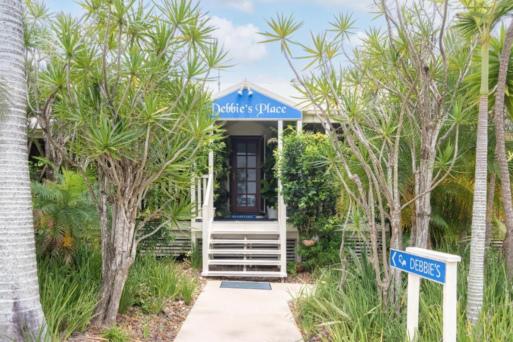 a house with a blue sign in front of it at Debbie's Place in Rainbow Beach