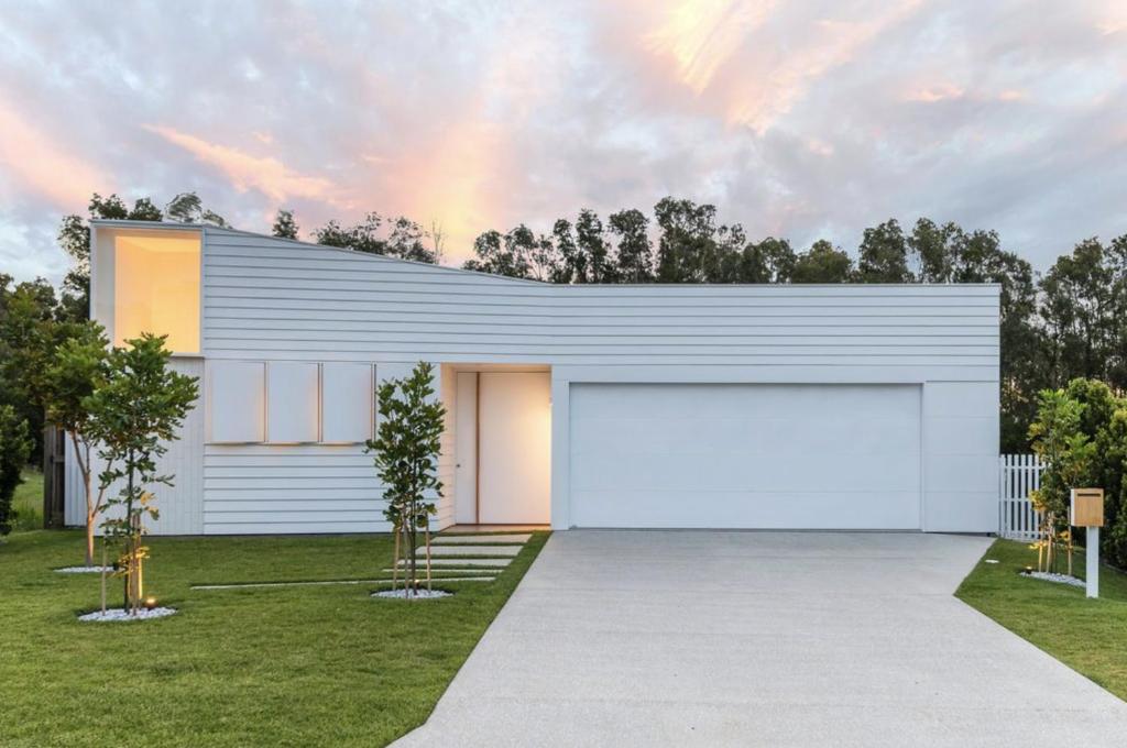 a white building with a large garage at The Luxury White House in Peregian Springs