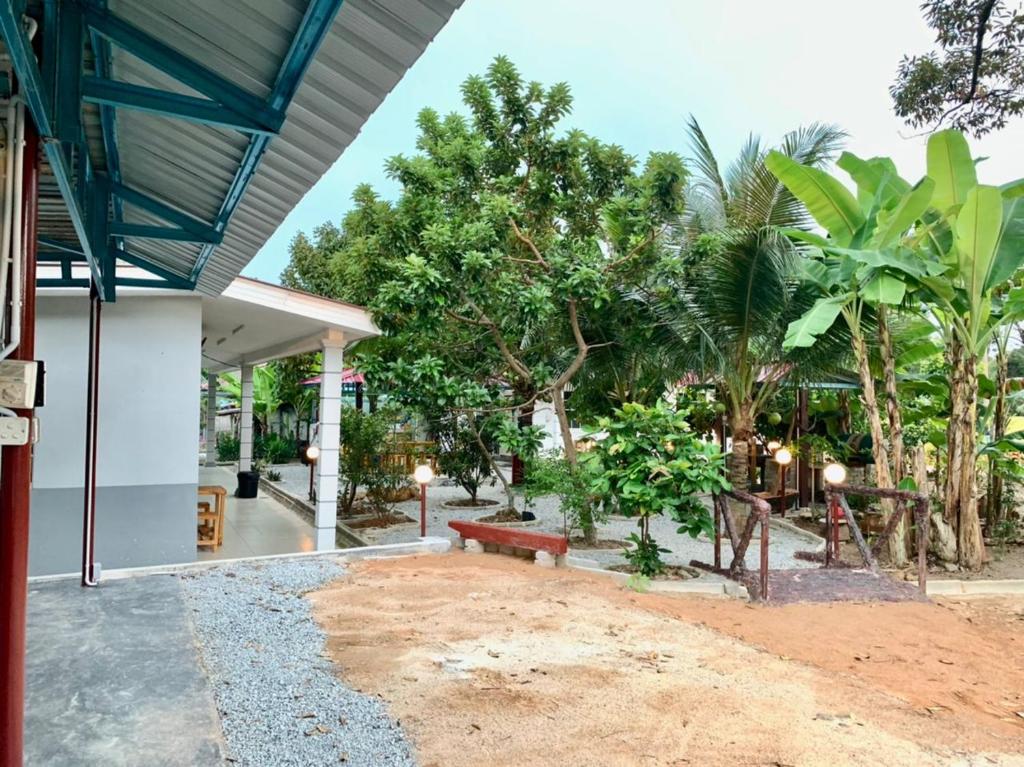 a patio of a house with a bench and trees at VILLA D' KEBUN WITH FREE FRUITS in Melaka