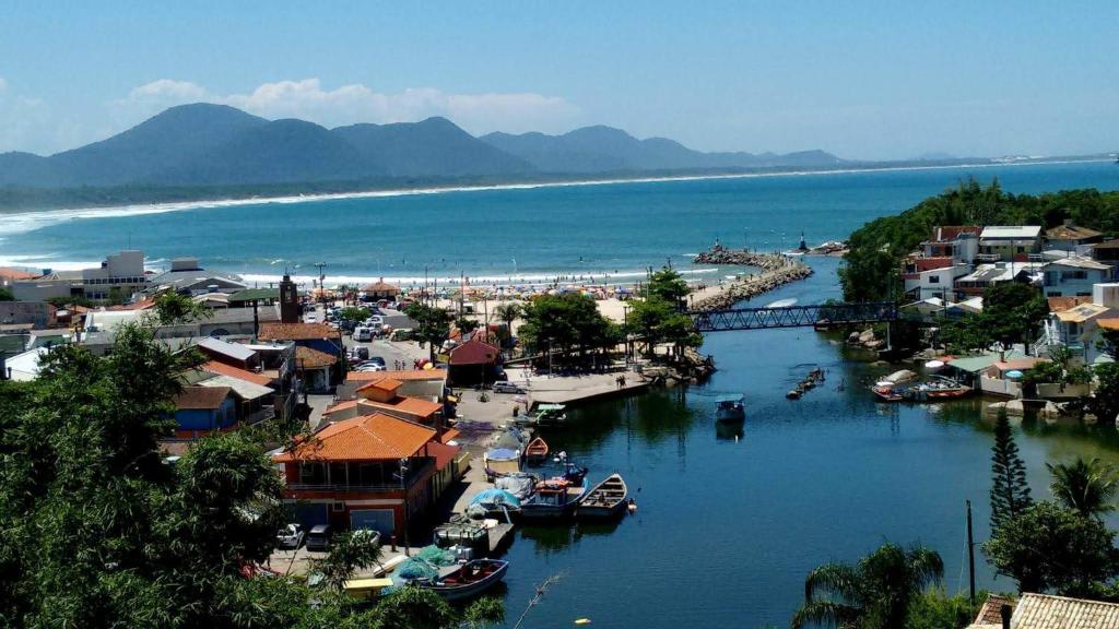 a town with boats in a river next to a beach at Hostel Vista da Barra in Florianópolis