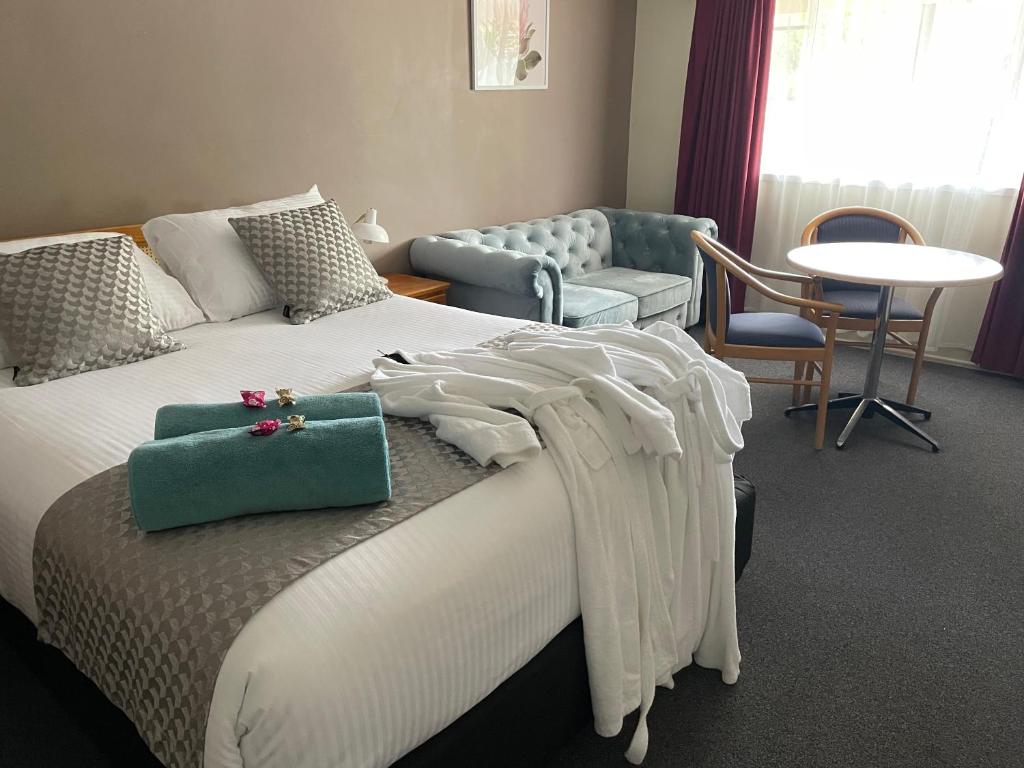 un dormitorio con una cama con un bolso verde en Highlands Motor Inn, en Oberon
