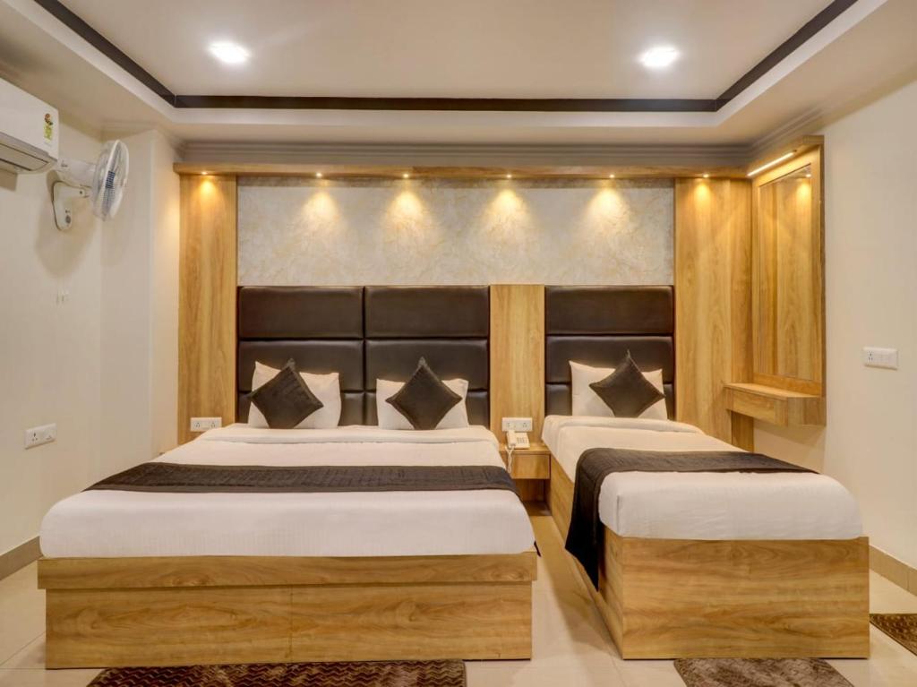 新德里的住宿－HOTEL DAKHA INTERNATIONAL - Karol Bagh, New Delhi，卧室内的两张床,墙上有灯
