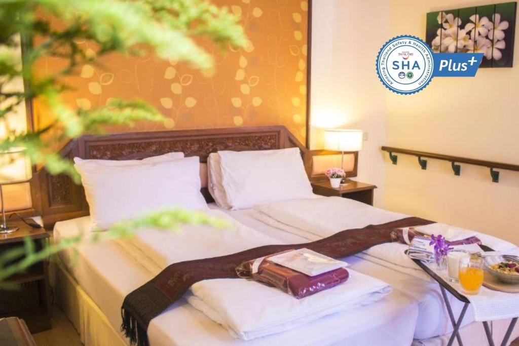 People Place Boutique In Town Hotel - SHA Extra Plus في شيانغ ماي: سرير في غرفة الفندق عليه منشفتين