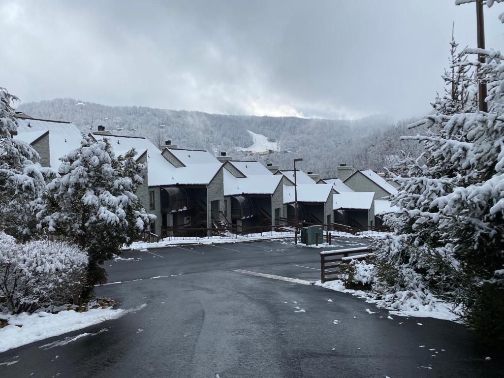 a snow covered street in a village with houses at Two bedroom mountain condo, 2 minutes from ski resort, pool and clubhouse onsite ! in Gatlinburg