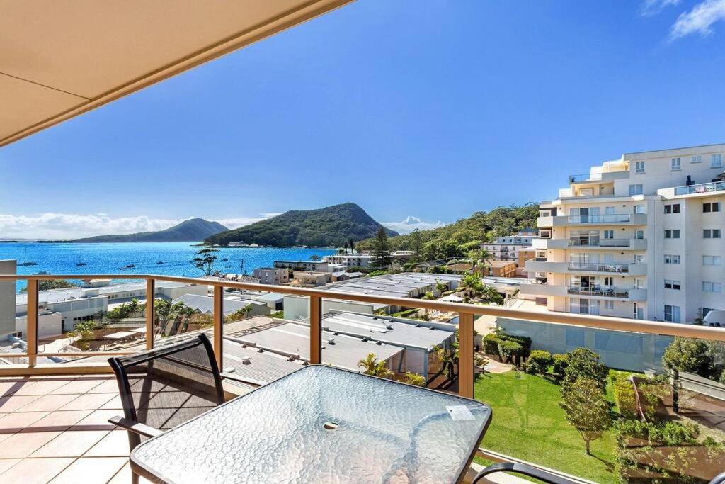 a balcony with a view of the ocean and buildings at 814 Shoal Bay Waterviews in Shoal Bay
