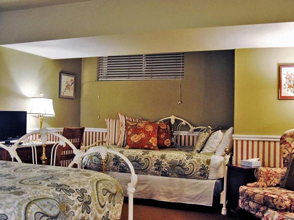 a bedroom with a bed and a table and a chair at Cecil Bacon Manor in Seattle