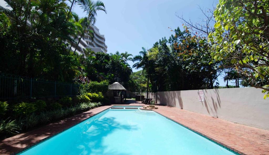 - une piscine avec un kiosque et des arbres dans l'établissement 202 Ipanema Beach, à Durban