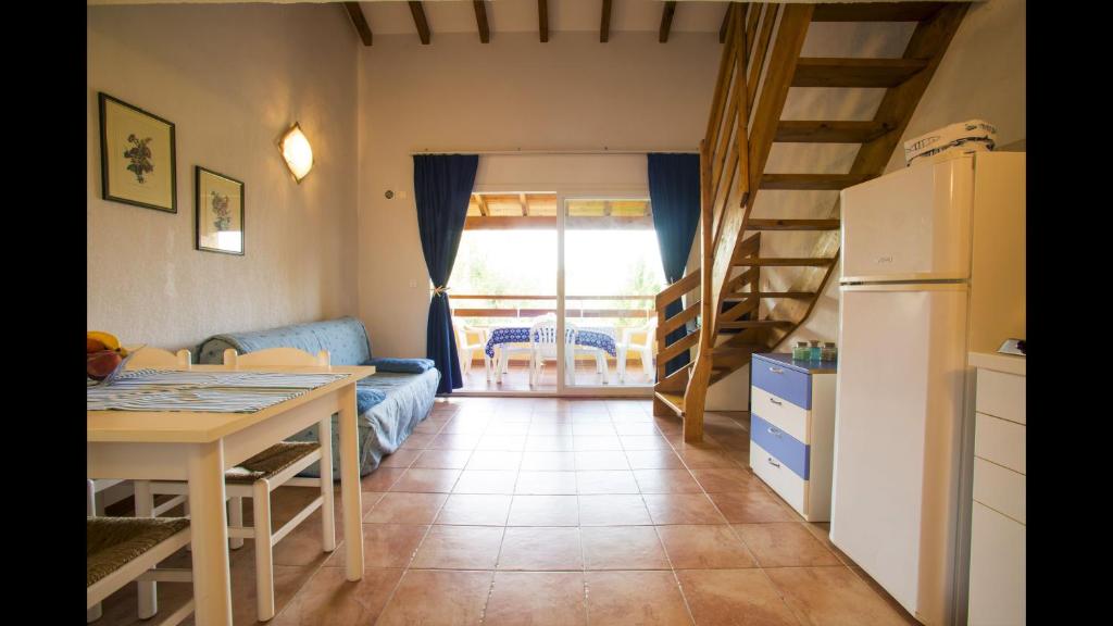 Il dispose d'une cuisine et d'un salon avec une table et un réfrigérateur. dans l'établissement Apartment for 6 people on the sea, à Ghisonaccia