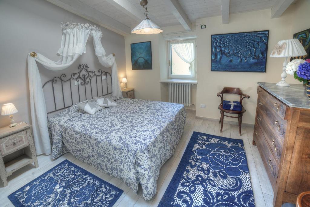 ヴェルバーニアにあるLa Foresteriaのベッドルーム1室(青と白のシーツ、青のラグ付)