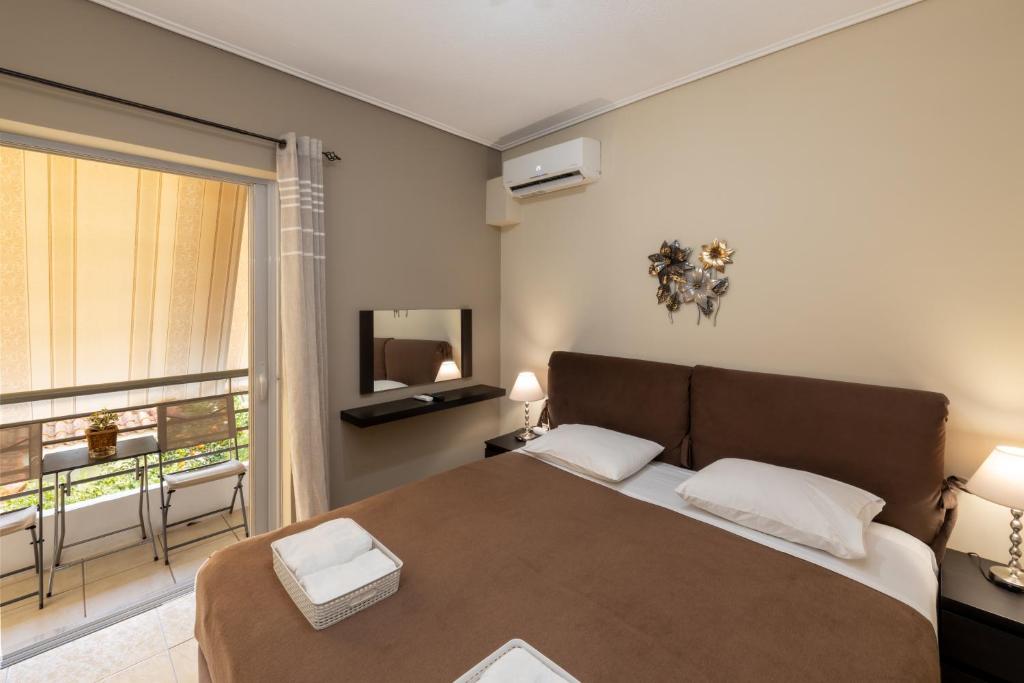 a bedroom with a large bed and a window at A&J Apartments or Rooms athens airport in Markopoulo