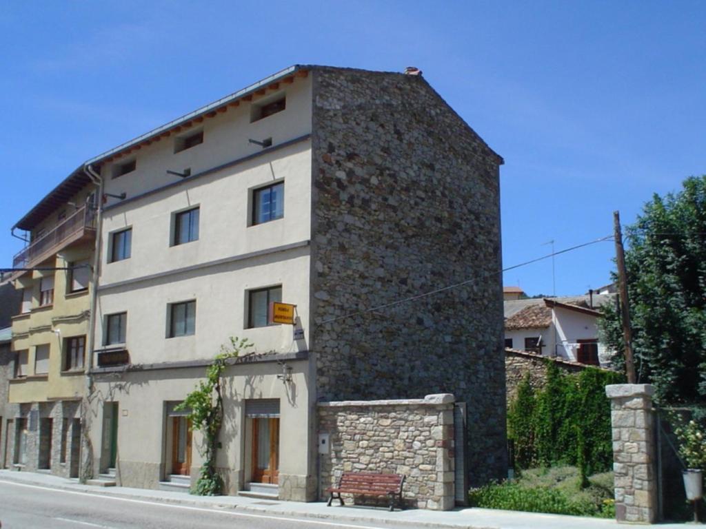 un gran edificio de piedra en el lateral de una calle en Fonda Muntanya, en Vilaller