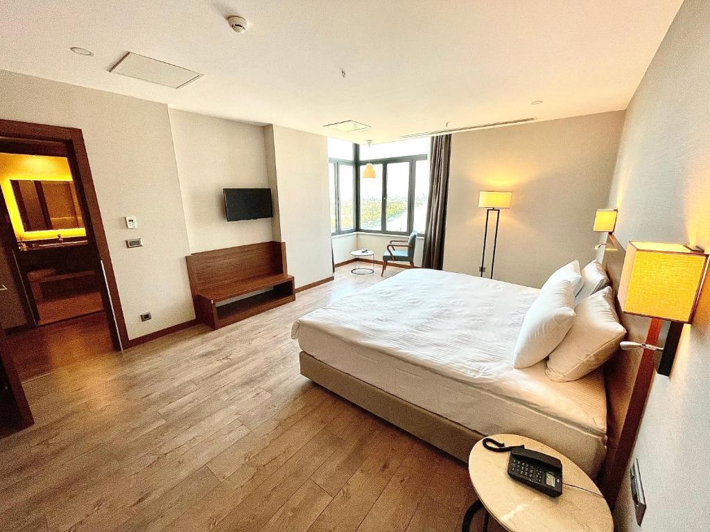 A bed or beds in a room at Türkmen Riverside Hotel Adana