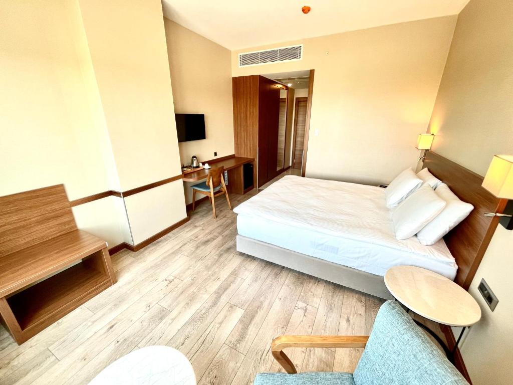 A bed or beds in a room at Türkmen Riverside Hotel Adana