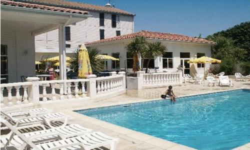 uma mulher sentada numa piscina numa casa em Hotel & Restaurant Le Mejean - Parc des Expositions em Lattes